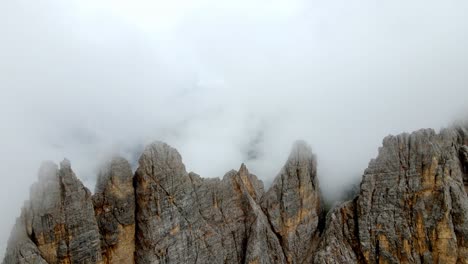 Aerial-views-of-mountain-range-in-the-Dolomites,-Italy,-in-a-foggy-day