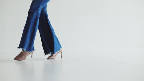 Artistic-close-up-shot-of-woman-walking-in-baggy-jeans-and-heels