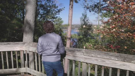 Frau,-Die-Den-Au-Sable-River-In-Michigan-Auf-Aussichtspunkt-Während-Der-Herbstfarben-Mit-Kardanischem-Video-Betrachtet,-Das-Sich-Vorwärts-Bewegt