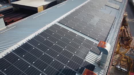Set-Of-Solar-Panels-On-Top-Of-Industrial-Building,-Renewable-Energy-System