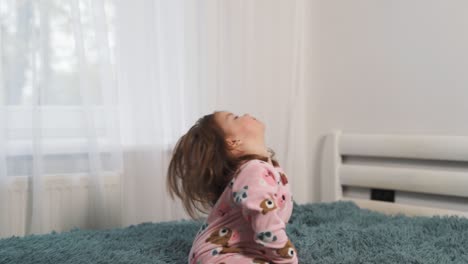 A-little-two-year-old-child-is-playing-and-jumping-on-a-big-bed