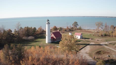 Tawas,-Michigan-lighthouse-along-Lake-Huron-with-drone-low-and-moving-forward