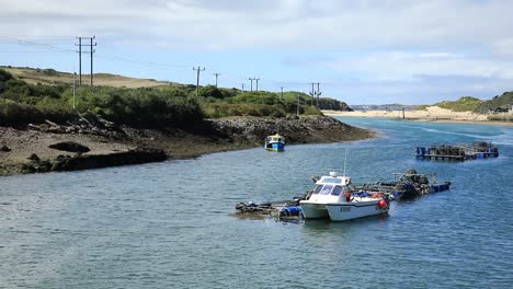 White-Boat-Anchored-In-Hayle-Town-Port,-Blue-Water,-Cornwall,-England