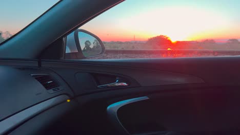 Car-Driving-On-The-Road-With-Beautiful-Sunset-Scenery-Through-The-Window-On-Passenger's-Side