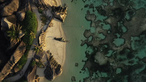 Imágenes-Aéreas-De-Drones-Volando-Sobre-Personas-En-El-Agua-Al-Atardecer-En-La-Isla-De-La-Digue-En-Las-Seychelles