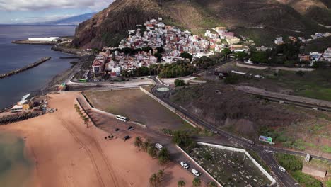 Aerial-view-of-colorful-town-near-golden-beach-and-mountain,-Tenerife