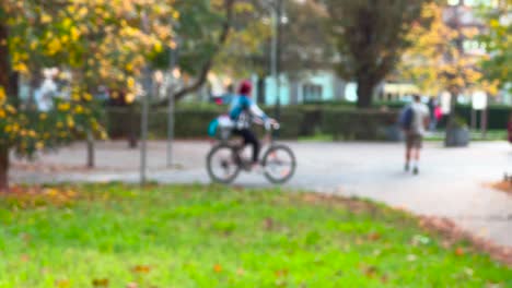 Defokussierte-Person,-Die-Im-Herbstpark-Fahrrad-Fährt