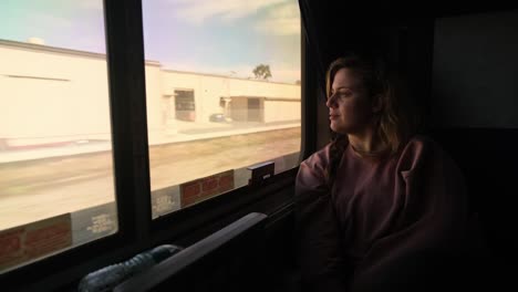Woman-on-Train-Looks-Peacefully-Out-Window-as-Terrain-Rolls-By