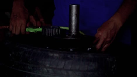 Close-up-shot---The-mechanic-is-filling-air-into-a-car-tire-through-a-compressed-air-hose