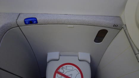 Airplane-bathroom-closed-lid-with-prohibited-sign-panning-view,-onboard-airplane-interior-4k