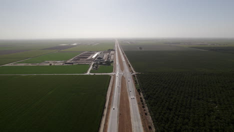 Vista-Aérea-De-Los-Campos-De-Maíz-Con-La-Carretera-Que-Atraviesa-En-California