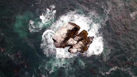 Aerial-Birds-Eye-View-Of-Pacific-Ocean-Waves-Crashing-Against-Small-Rock-Island-Off-Big-Sur