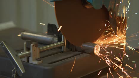 Close-up-shot-of-contractor-cutting-iron-stick-with-glowing-sparks