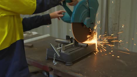 Shot-of-contractor-hands-cutting-iron-stick-with-glowing-sparks