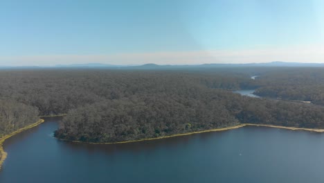 Aerial-shot-panning-accross-a-lake-in-the-Australian-wilderness-with-mountains-in-the-background