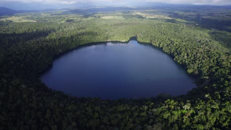 Lake-Eacham-Crater-Lake-Surrounded-With-Lush-Rainforest-In-Atherton-Tableland,-Queensland,-Australia---aerial-shot