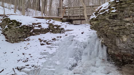 Frozen-Waterfall-And-Wooden-Footpath-During-Winter-In-Niagara-Escarpment,-Ontario,-Canada