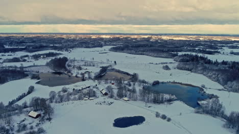 Rural-village-in-snowy-landscape-with-ponds-in-winter-season