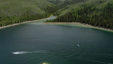 Aufschlussreiche-Drohnenaufnahme-Von-Booten,-Die-An-Einem-Sonnigen-Sommertag-Auf-Einem-Bergreservoir-Treiben,-Schwenk-Nach-Unten-In-Utah