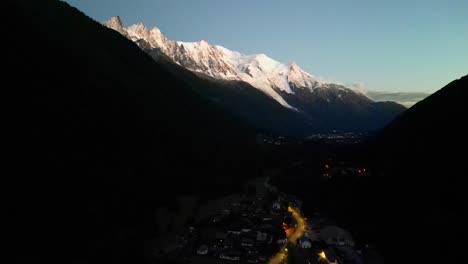 Mont-Blanc-Glacier-in-Evening---Illuminated-Mountains-and-Road---Aerial-Dolly-Forward