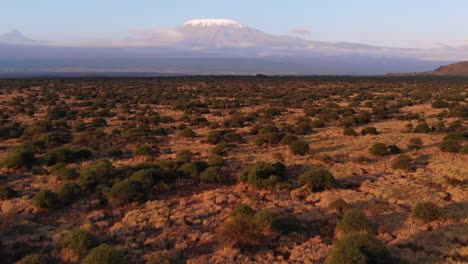 Drone-shot-of-Kilimanjaro-mountain-in-the-distance-after-the-valley