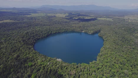 Lush-Rainforest-Surrounding-Lake-Eacham-In-Atherton-Tableland,-Queensland,-Australia---aerial-drone-shot