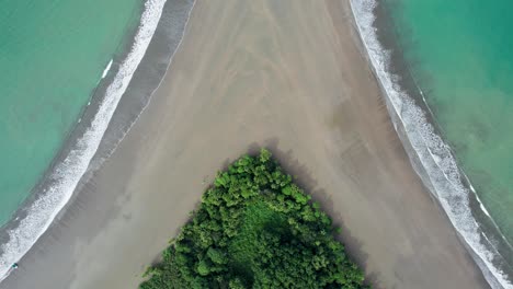 Overhead-shot-of-tropical-beach-with-rainforest-zooming-into-sand
