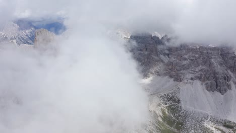Luftflug-Durch-Dichte-Wolken-Und-Felsige-Berge-Im-Hintergrund---Tre-Cime-Di-Lavaredo-Türme