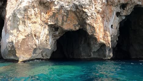 Sideways-boat-point-of-view-of-Vedusella-or-Verdusella-caves-on-Adriatic-side-of-Mediterranean-sea,-Italy