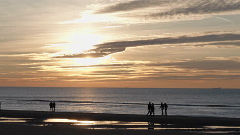Silhouette-Von-Paaren-Am-Strand-Von-Egmond-Aan-Zee-In-Den-Niederlanden-Bei-Sonnenuntergang-Zur-Goldenen-Stunde