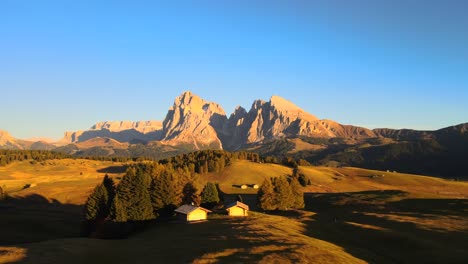 Berge,-Wald-Und-Wiesen-Mit-Holzhütten,-Gefilmt-Auf-Der-Seiser-Alm-In-Den-Europäischen-Alpen,-Italienische-Dolomiten,-Gefilmt-In-Leuchtenden-Farben-Bei-Sonnenuntergang