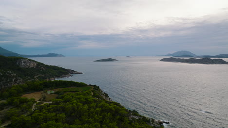 Vista-Aérea-Desde-La-Costa-Occidental-De-Rodas-De-Islotes-En-El-Mar-Egeo-Al-Atardecer