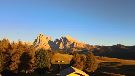 Mountains,-forest-and-grass-fields-with-wooden-cabins-filmed-at-Alpe-di-Siusi-inEuropean-Alps,-Italian-Dolomites-filmed-in-vibrant-colors-at-sunset