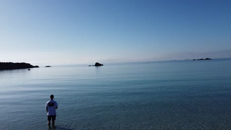 Mann-Steht-Im-Klaren-Wasser-Einer-Bucht-Auf-Korsika