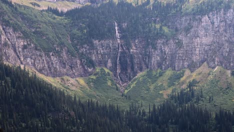waterfall-from-a-melting-glacier-with-a-break-in-the-clouds-for-a-little-light,-late-September-2022-in-Glacier-National-Park,-Montana