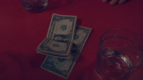 Geld-Sitzt-Neben-Einem-Getränk-Auf-Einem-Roten-Tisch