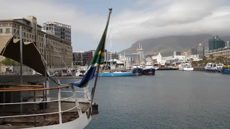 South-African-flag-flutters-on-boat-in-Alfred-Basin-Harbour,-Cape-Town