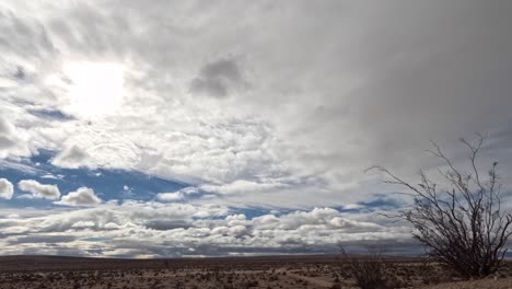 Mojave-Wüste-Mit-Einem-Sonnenhalo-Hinter-Einer-Dynamischen-Wolkenlandschaft---Zeitraffer-An-Einem-Windigen-Tag