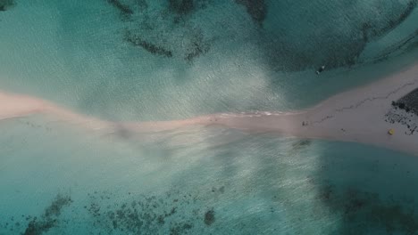 Aerial-shot-sandbar-being-swallowed-by-the-ocean's-waves-with-turquoise-sea-water,-Cayo-de-agua