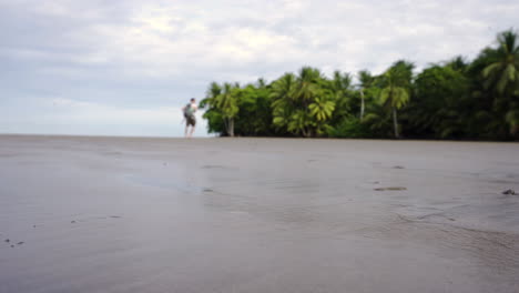 Einsame-Rucksackreisende,-Die-Allein-Am-Sandstrand-Von-Costa-Rica-Uvita-Mit-Tropischem-Palmendschungel-Spazieren-Gehen