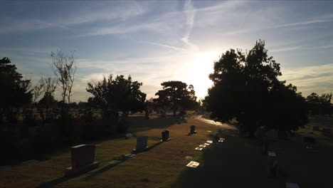 Slow-aerial-dolly-through-a-cemetery-during-sunset