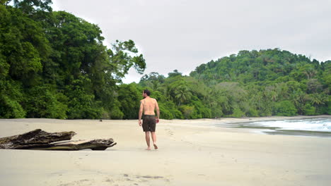 Hombre-Solitario-Caminando-En-Una-Playa-Tropical-De-Arena-Blanca-En-Costa-Rica-Explorando-La-Zona-Selvática-De-América-Central