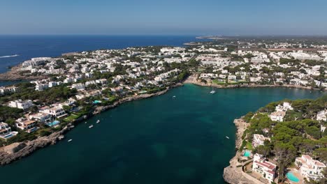 Far-away-aerial-view-taken-with-drone-of-the-white-houses-of-the-city-of-Cala-d'Or,-Mallorca