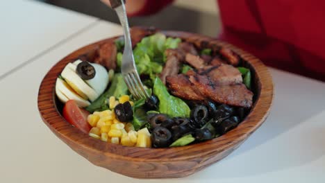 Eating-Healthy-Green-Salad-With-Olives,-Corn-Kernels