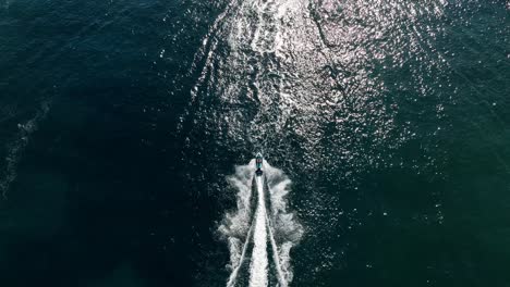 Aerial-view-taken-with-drone-following-a-jetski-on-water-in-slowmotion