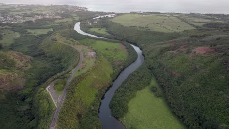 Dramatic-aerial-footage-of-famous-Wailua-River-with-Pacific-ocean-coastline-and-a-driveway-Jungle-landscape-Kauai-Hawaii-with-waterfalls-and-scenic-natural-wonders