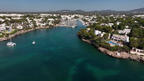 Aerial-view-with-drone-flying-over-the-harbor-of-Cala-d'Or-located-on-Mallorca-with-boats-and-yachts