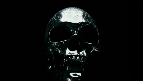 Water-Droplets-on-Glass-Ice-Silver-Skull-Rotating-on-Black-Background