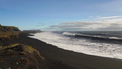 Panorama-Of-Black-sand-Beach-With-Crashing-Waves-In-Summer