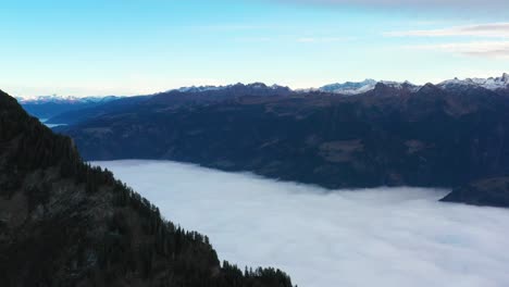 Panning-shot-showing-the-valley-filled-with-a-wall-of-clouds-in-the-Swiss-Alps